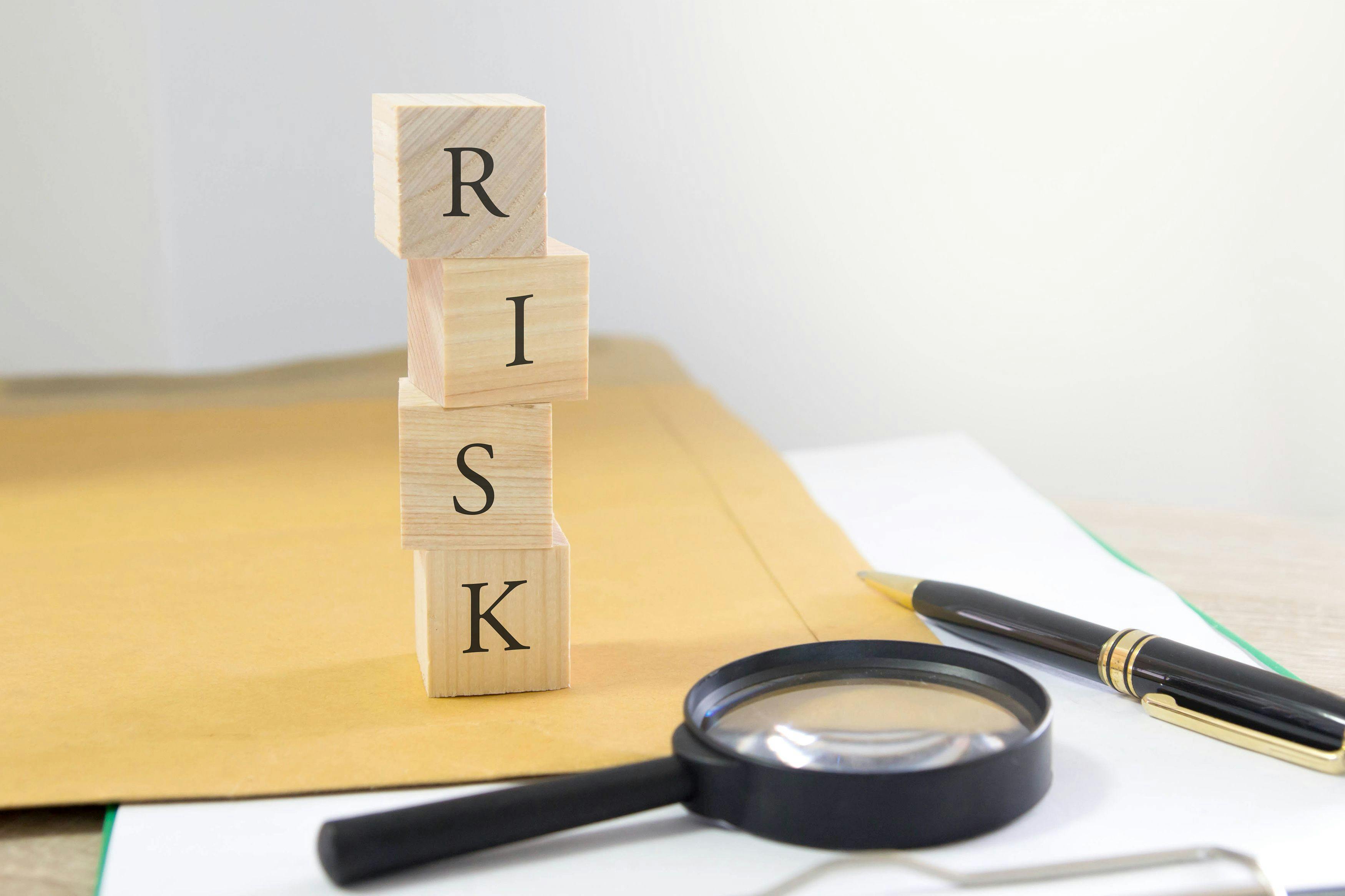 risk written on blocks and a magnifying glass | © janews094 - stock.adobe.com