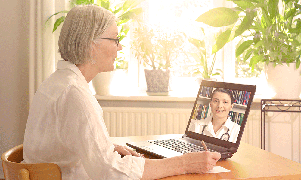 elderly patient writing during virtual doctor telemedicine visit